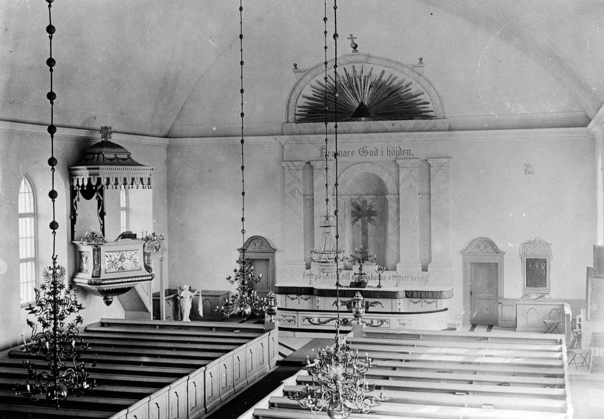 Interiör från Landskyrkan i Alingsås med bänkar, predikstolen och altaret.