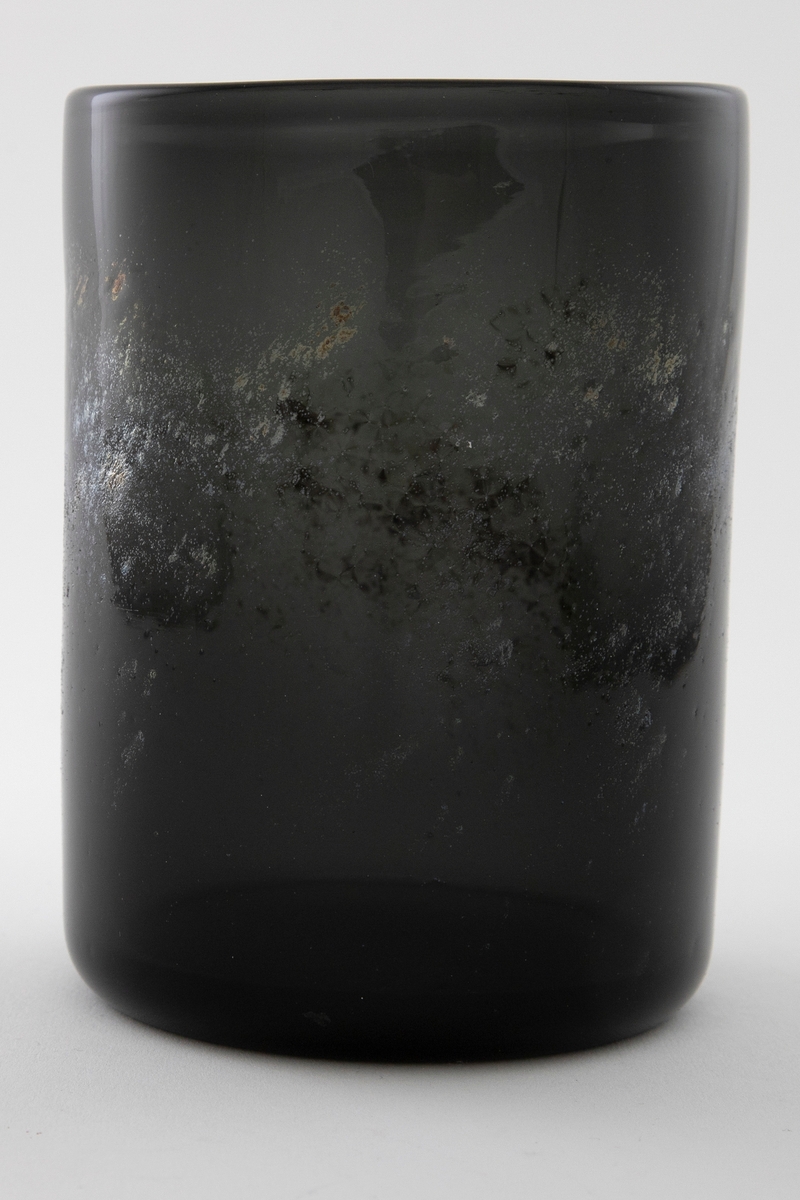 Sylinderformet vase i røykfarget halvgjennomsiktig glass dekorert med uregelmessig metallstøv.