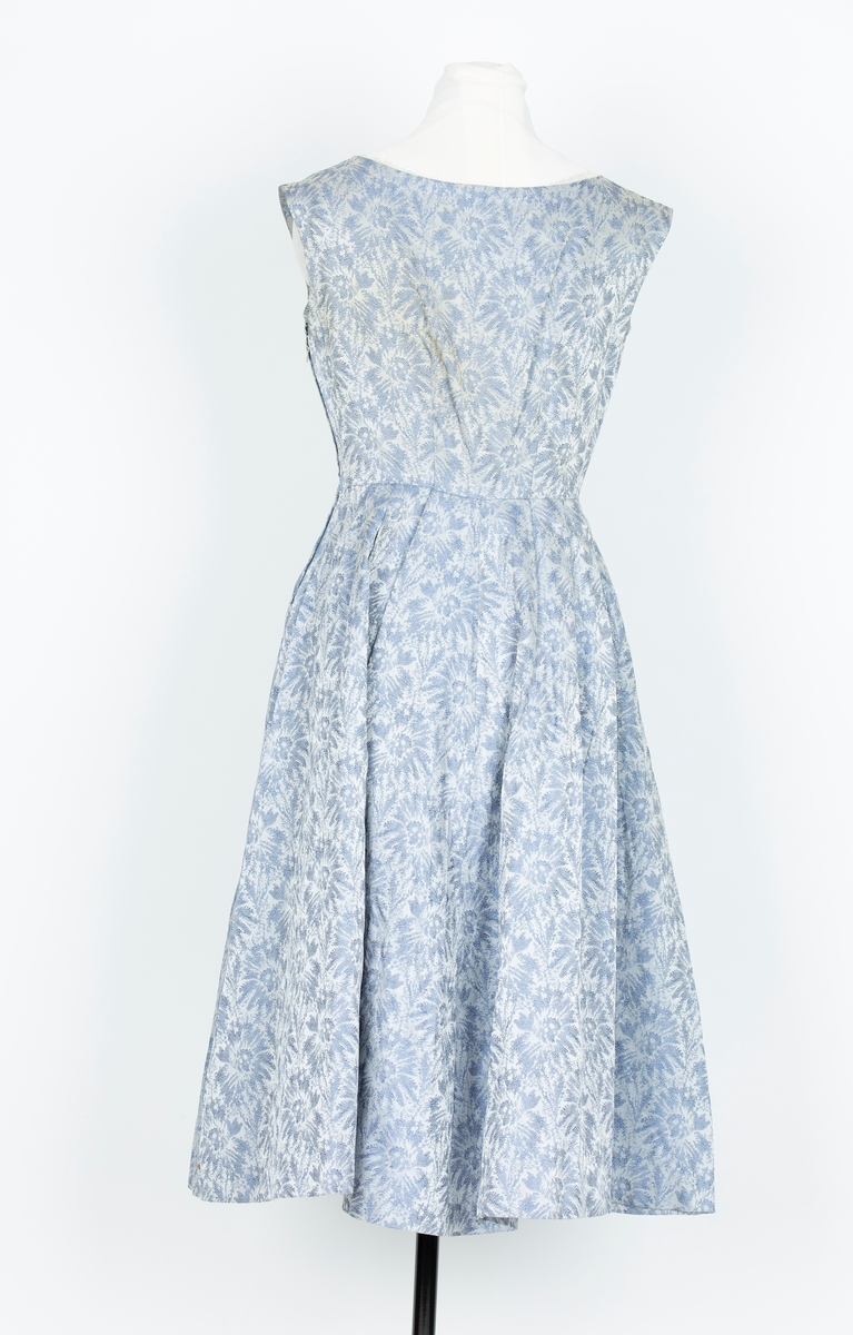 Selskapskjole. gråblå/blå brokade. Tettsittende lliv, lengdesnitt. Båtformet halsringing. Uten ermer. Pyntesløyfe av stoffet i halsringing. Skjørt i fire skrådde bredder lagt i legg mot livet, utskrådd wienerfold midt foran og bak.
Skjørtevidde nesten som rundklippet.

"Denne kjolen sydde jeg til bryllupet til Pers søster.svigerinne, våren 1956. Brukte den også i bryllupet til venninne St. Hansaften 1956 




kjortet er folde mot liv. Rund hals og uten erm. Glidelaas i siden. Sloyfe i halsen