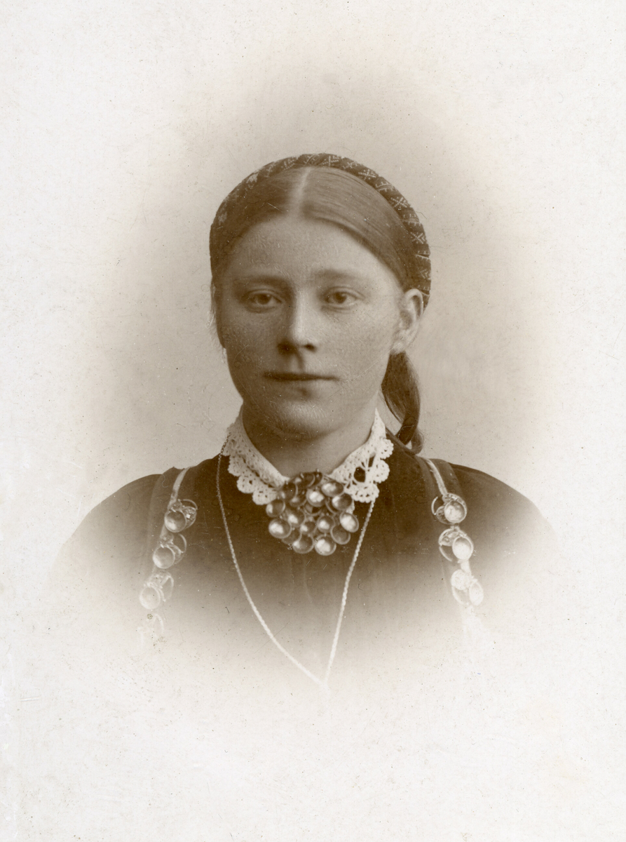 Brystbilde av yngre kvinne i beltestakk: Gunhild Johnsdotter Sisjord. f. Kåsa (Midtbø)