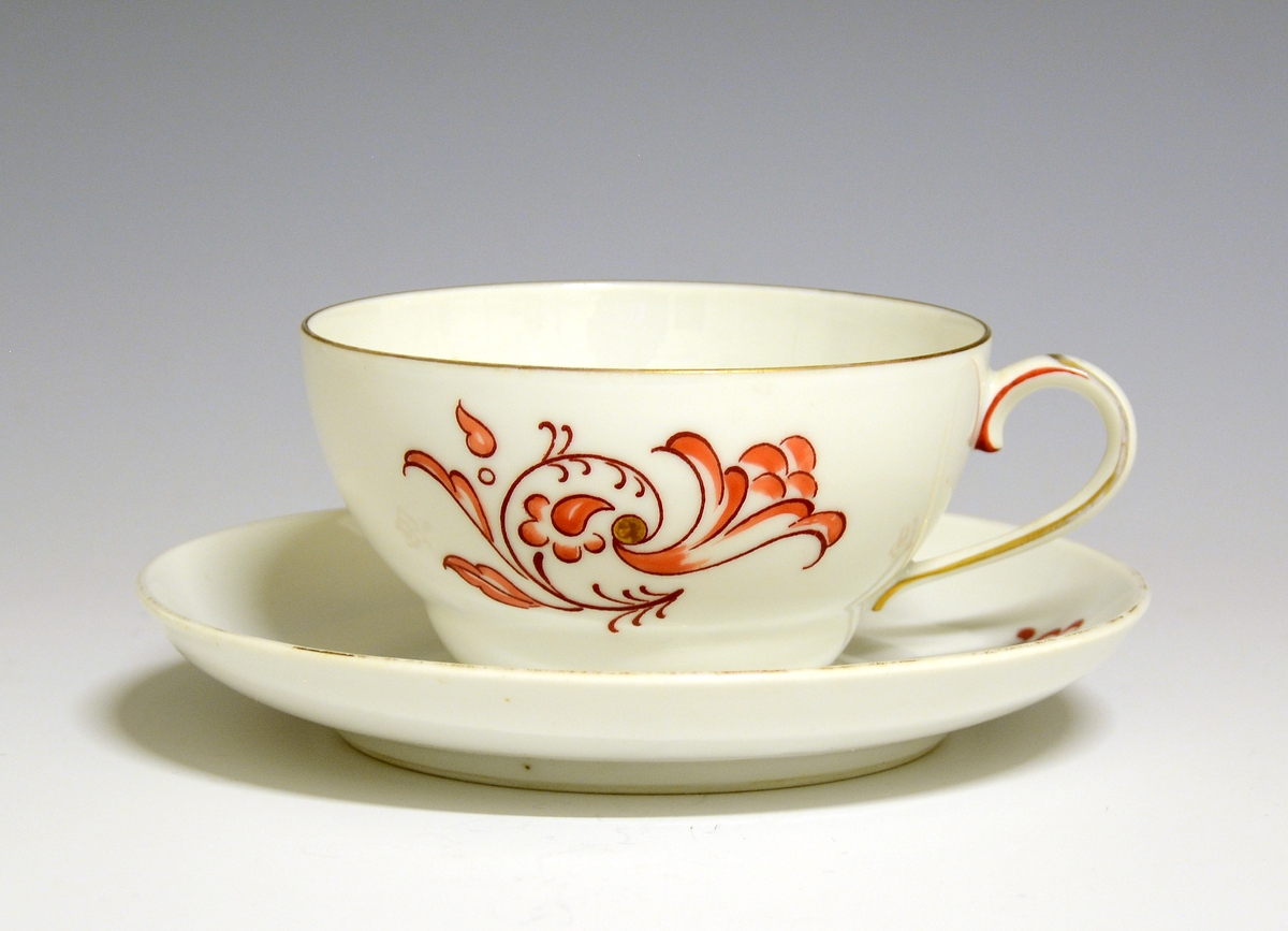 Kaffekopp med skål av porselen. Hvit glasur. Dekorert med stilisert rankemotiv i rødt. 
Modell: 377 (usikker)

Fabrikkmerke: Grønt anker med PP (1911-1935).
Finnes i priskuranten for 1931.