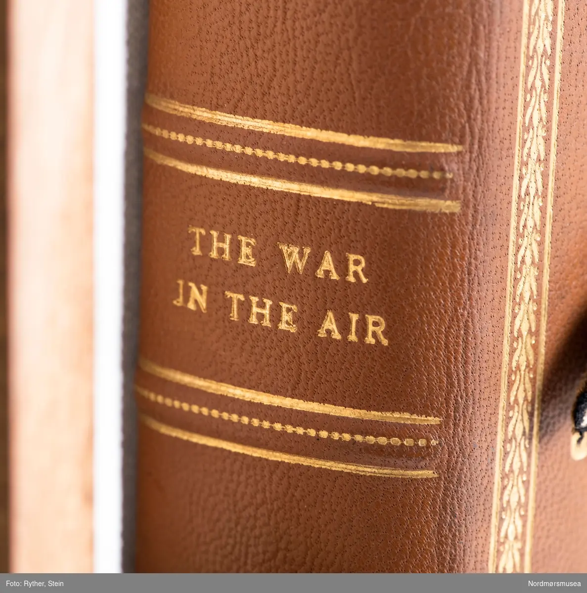 Boken "The war in the air, vol. IV" av H.A Jones. Trykket i 1934 av Clarendon Press, Oxford. Medfølger et monter. Omgjort til et minnealbum av tidligere eier. Inneholder fotografier, håndskrevne ark og tegninger med påført tekst.