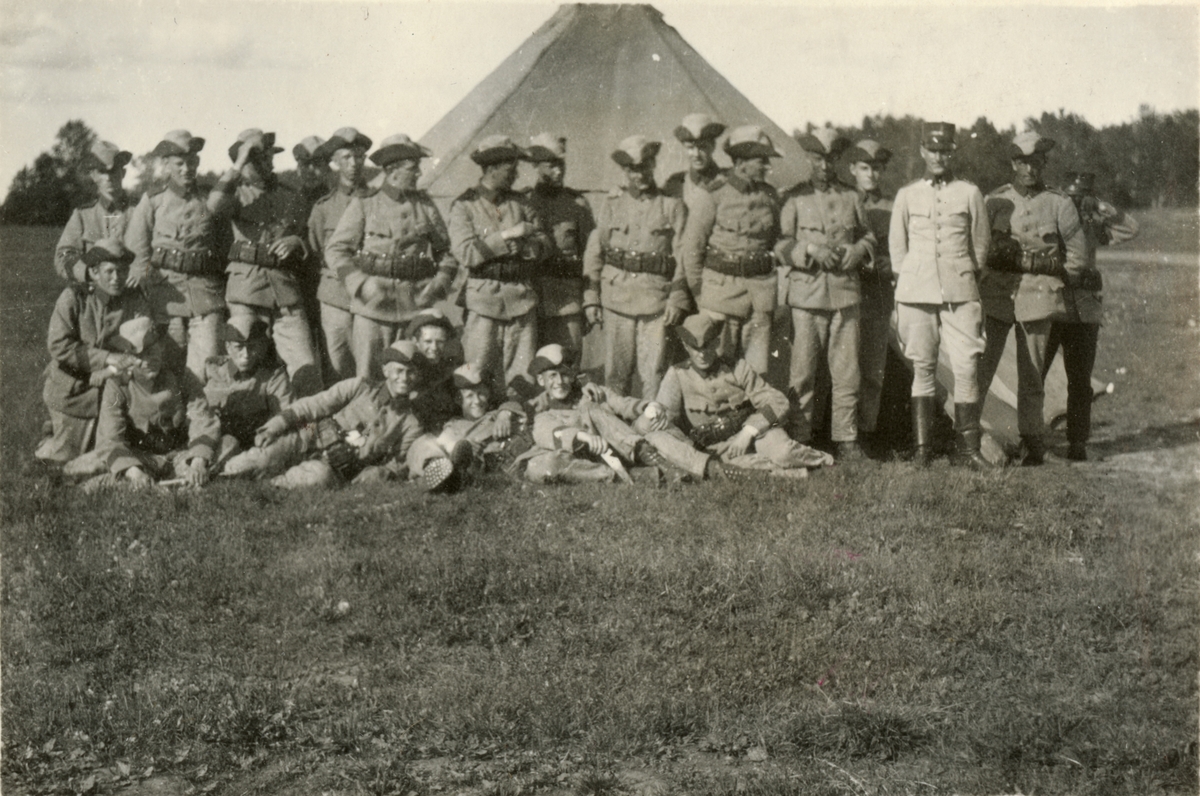 Gruppfoto med soldater framför ett tält.
