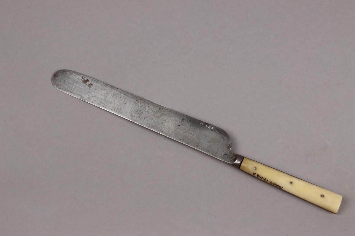 Bordskniv av kolstål med hantag av ben nitade med metallstift. Knivbladen stämplade A. M. ZANDER ESKILSTUNA.