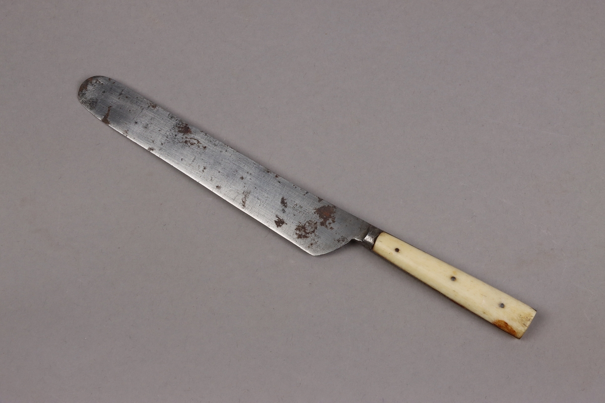 Bordskniv av kolstål med hantag av ben nitade med metallstift. Knivbladen stämplade A. M. ZANDER ESKILSTUNA.