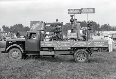 Lastebil med reklametekst for Norrøna skofabrikk langs sidelemmen på lasteplanet.