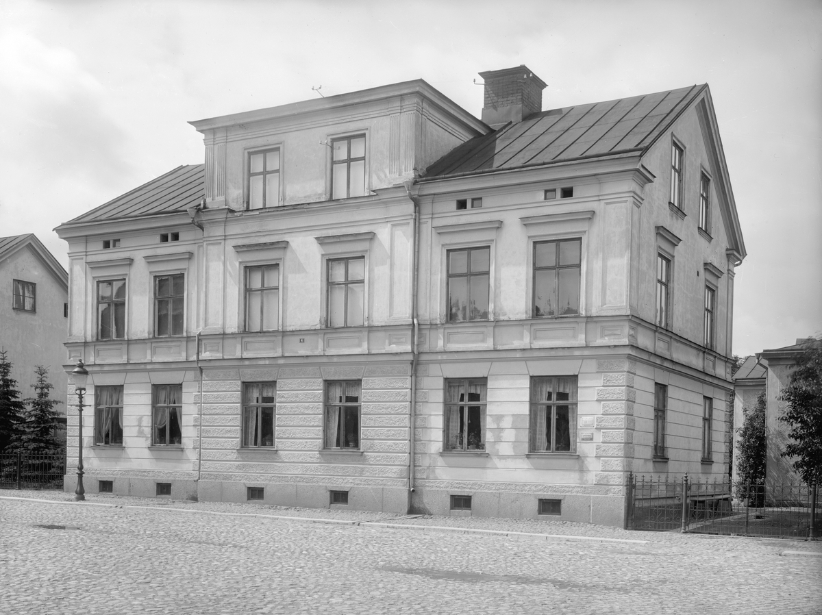 Vy mot Magasinstorget 4 i Linköping. Det reveterade trähuset uppfördes efter ritningar av stadsbyggmästaren Anders Lundqvist. Ritningarna är daterade 1881. Byggnaden revs 1980.