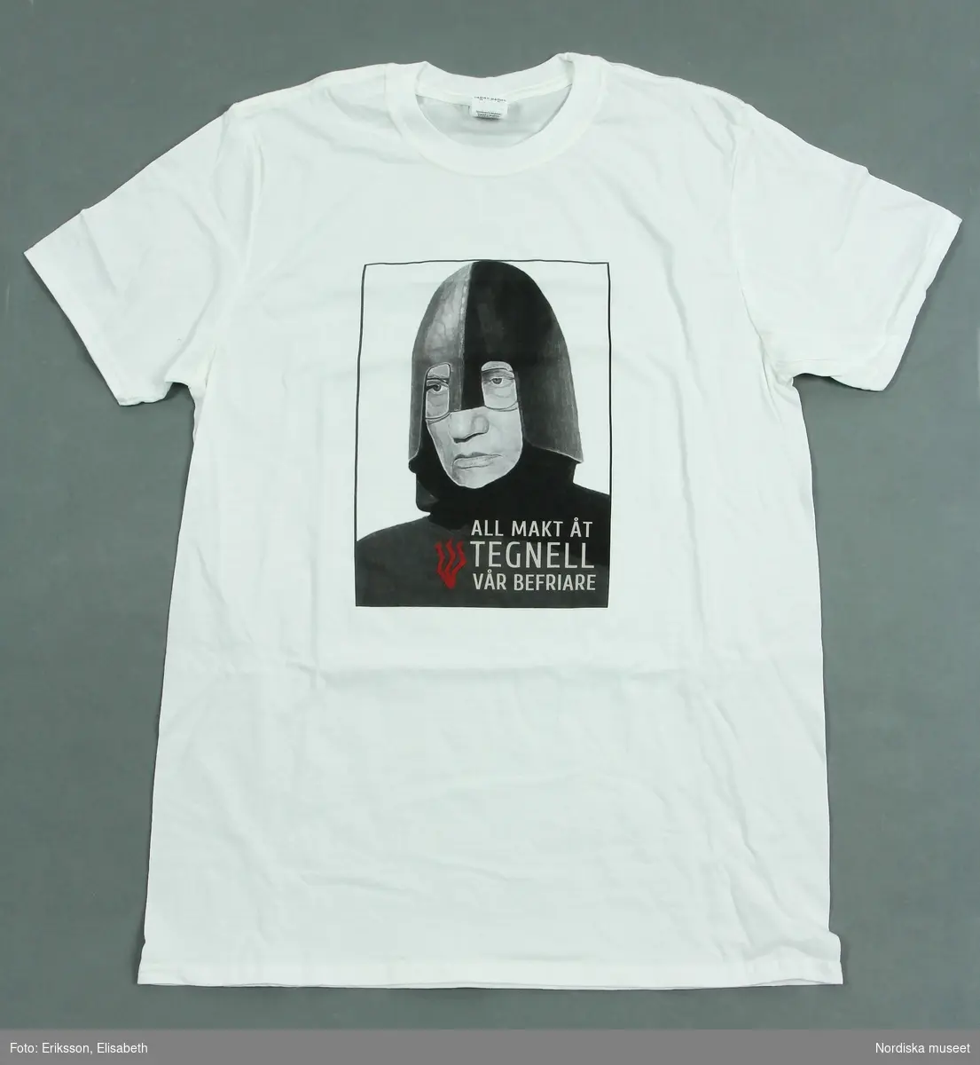 Vit t-shirt med kort ärm och svart tryck med motiv föreställande en riddare iförd hjälm samt texten "All makt åt Tegnell vår befriare".