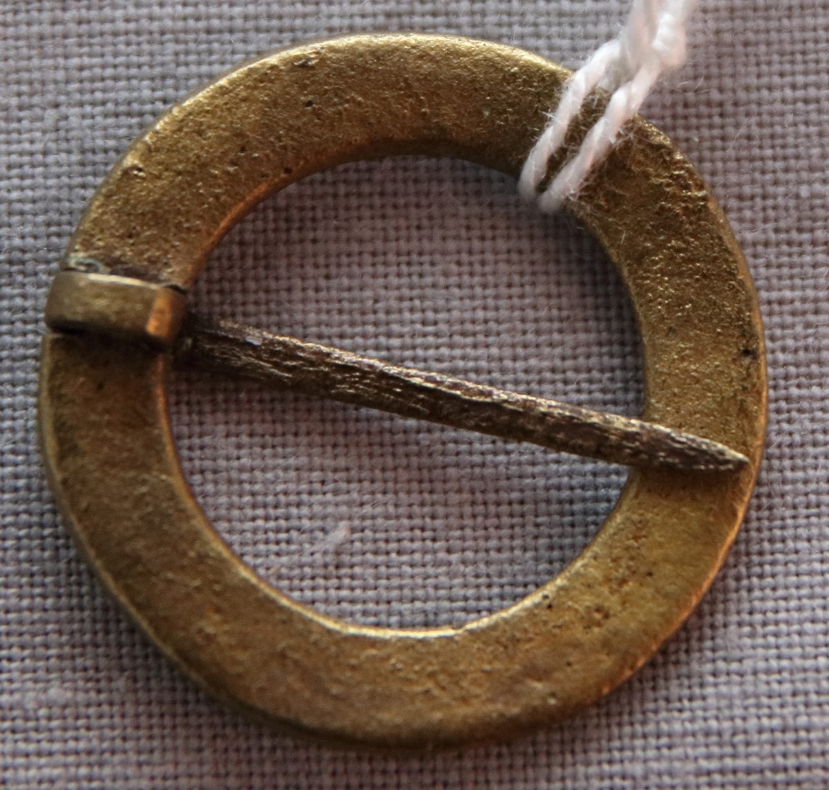 Brosch/ringsölja i mässings med tvärgående streckar och spänn-nål.