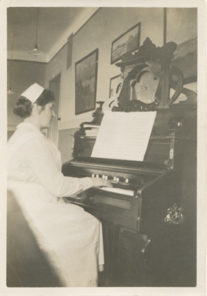 En kvinnlig sköterska spelar orgel på Stretereds skolvårdhem, okänt årtal.