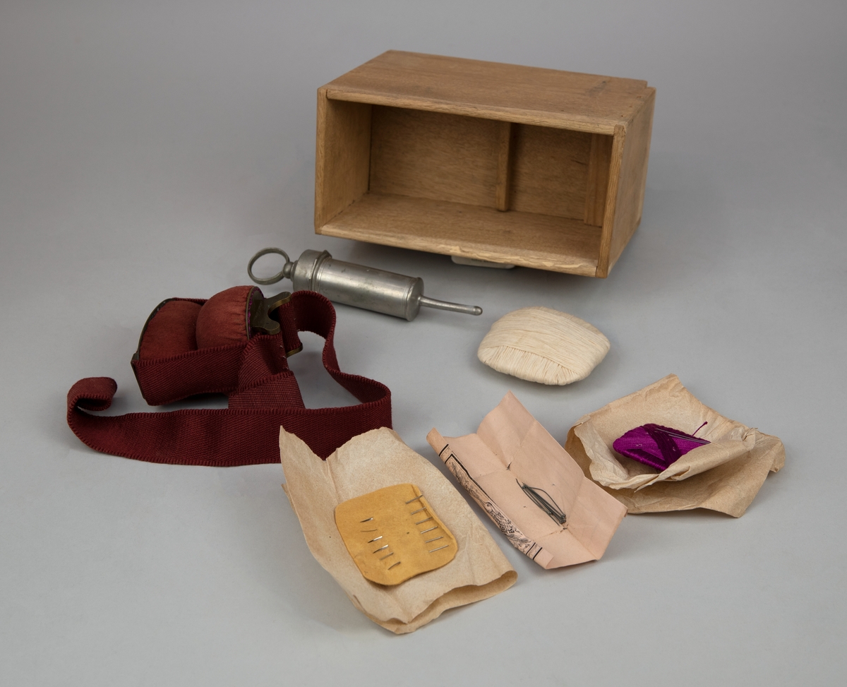 Sjukvårdslåda av trä (:1) med textilfodral (:2), nyckel (:3) och innehåll (:4-33). Locket stängs med gångjärn, haspar och nyckel. Metallskodda hörn, handtag på lådans kortsidor. Locket märkt "3DJE TRDT NO 8". På insidan av locket finns märke från tillverkaren ALB. STILLE. Textilfodralet stängs med läderremmar och metallspännen, hål på sidorna för handtagen.
Sjukvårdslådan innehåller en avlång trälåda (:4) med en såg (:5), fem knivar (:6-10), två krokar (:11-12) och tre tänger (:13-15). 
En till mindre trälåda (:16) med utrustning för koppning (:17-22). 
En trälåda utan lock (:23) med en spruta (:24), skruvtourniquet av sadelgjord med kuddar klädda med rött sämskskinn (:25) och nålförvaring (:26-29). 
En mindre svart läderväska innehållande bland annat tänger och skalpeller (:30).
Ett svart fodral med innehåll (:31).
Rem med kuddar klädda med rött sämskskinn (:32).
Spruta av metall (:33).