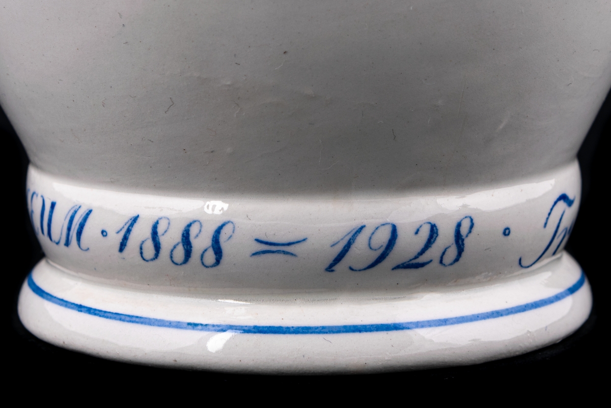 Kaffekanna med lock i flintgods, modell K, Abstrakt handmålad dekor i blått på vitt. Just denna kanna dekorerad för Triumfs 40-årsjubileum 1928 enligt målad dekor på fotringen; Triumf´s 40-ÅRSJUBIULEUM 1888-1928.