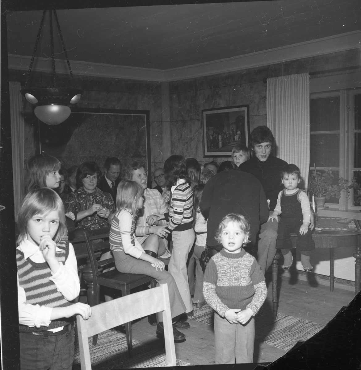 Vuxn och barn i ett rum. Det är Ölmstad hembygdsförenings julfest.