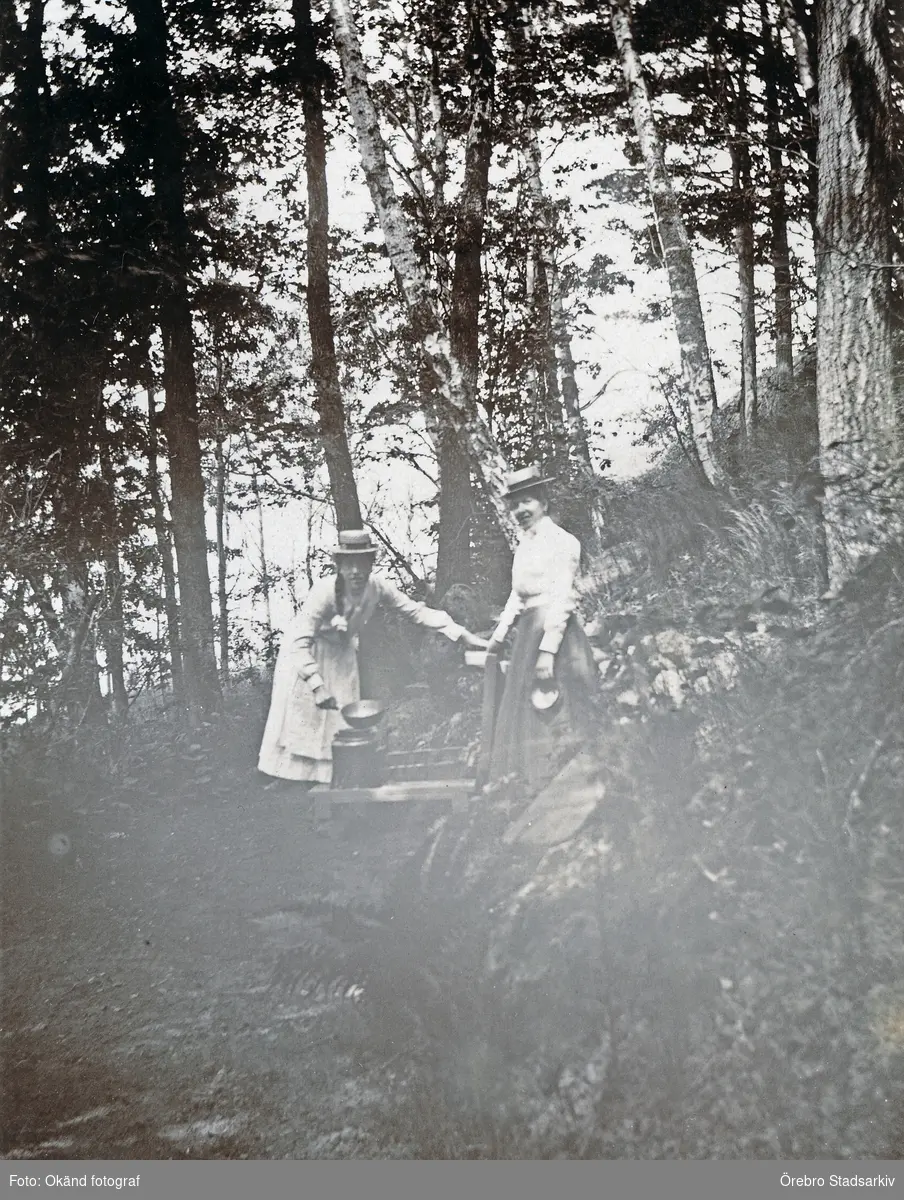 Två kvinnot vid källa i parken