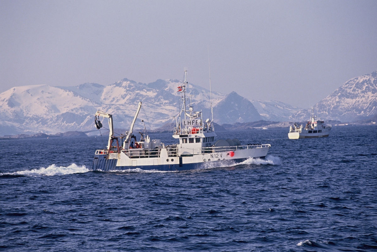 To fiskebåter på havet, Lofoten, med Lofotveggen i bakgrunnen