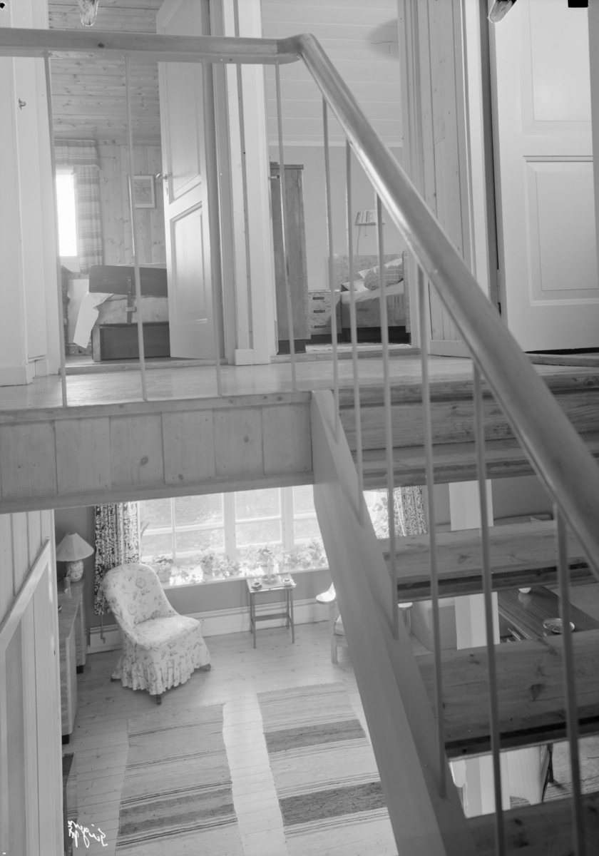 Interiørfoto av stue og trappeoppgang.