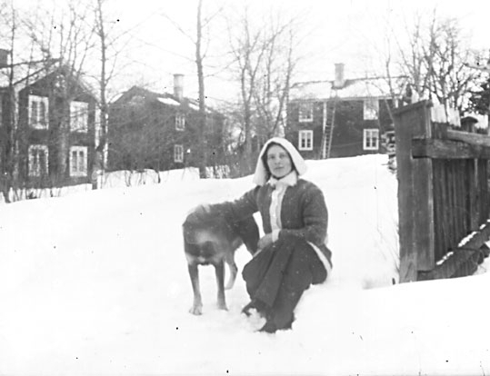 Porträtt, kvinna med hund i snön.