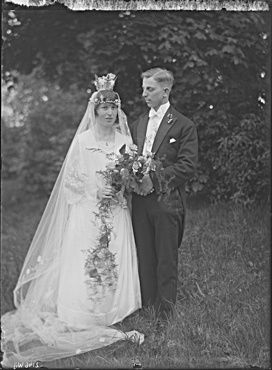 Fotografering beställd av Sundkvist. Föreställer vigseln mellan lantbrukaren Karl Leonard Vesterlund (1892-1982) och hans nyblivna hustru Astrid Vilhelmina Sundkvist (1895-1989). De vigdes i Badelunda den 12 juni 1924.