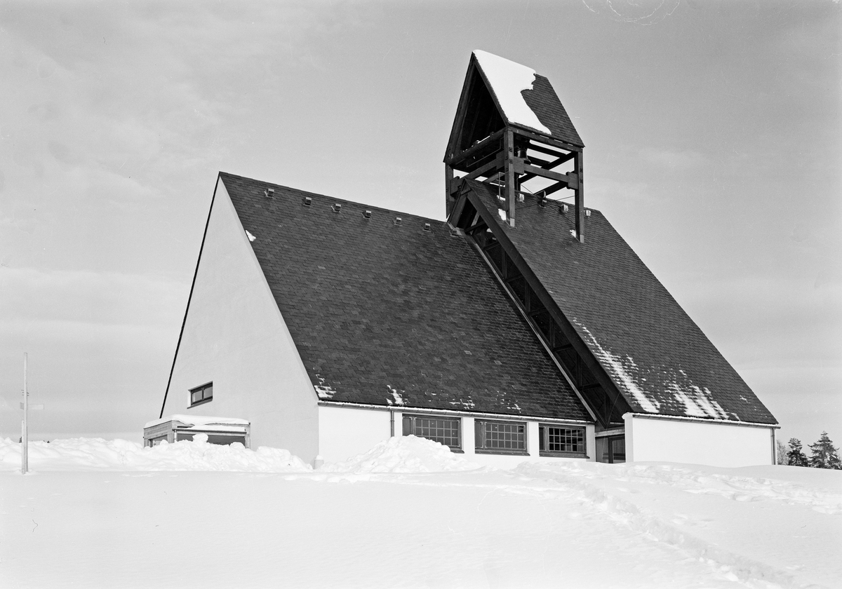 Eksteriørfoto av Holmen kirke. Kirken er tegnet av arkitekt Knut Knutsen som vant arkitektkonkurransen i 1958. Arbeidskirke oppført i betong. Vigslet i 1965.