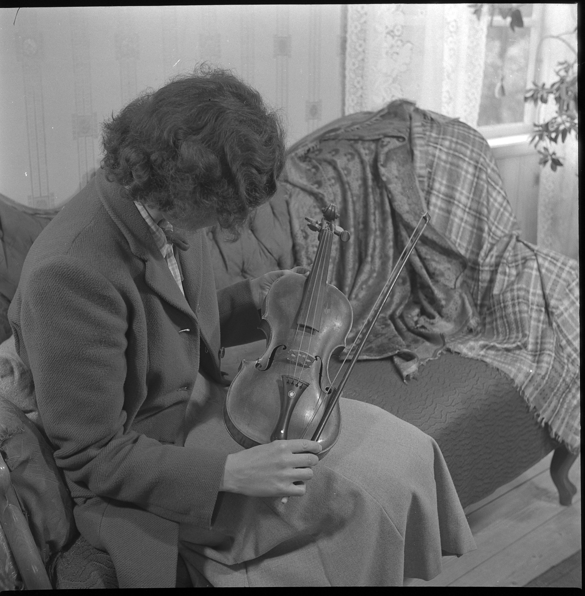 Fiol studeras. Maj 1950. Fotografens hustru Kerstin Åsén med fiolen inne i Läkarebos fg.