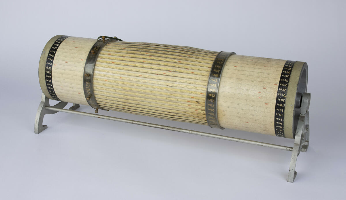 Regnemaskin, eller kalkulator, i en sylinderform av metall og papir. Trommelen kan roteres og støttes opp av metallrammen.