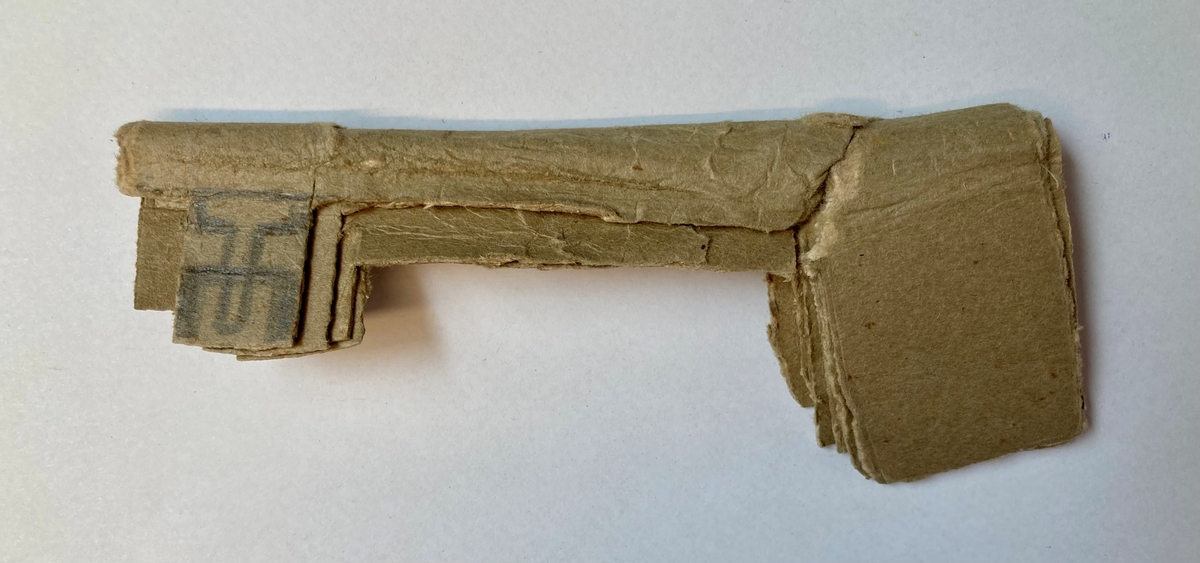 En nøkkelformet gjenstand laget av flere lag papp.