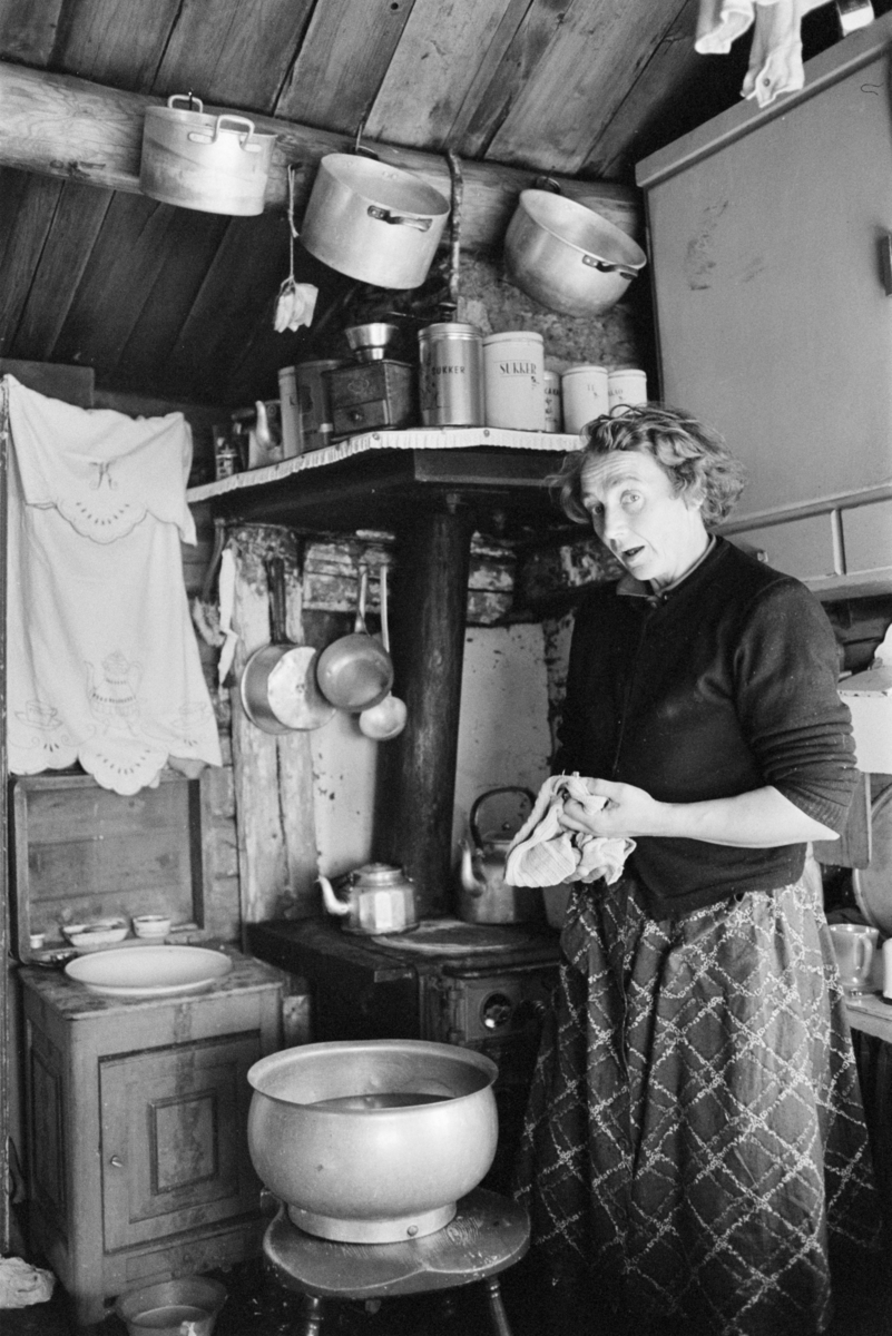 En kvinne tørker oppvask i et kjøkken på Røros.