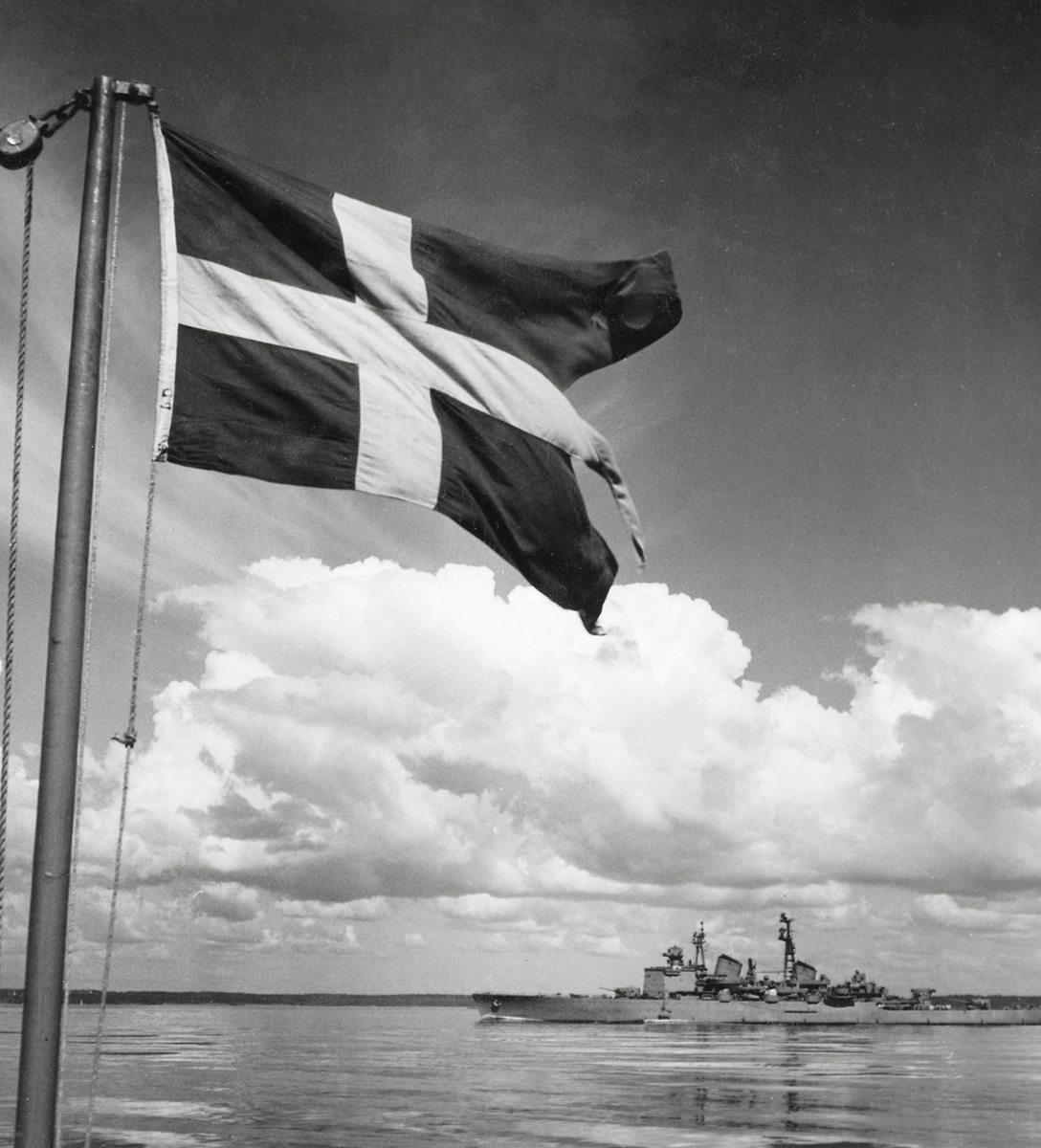 Kryssaren GÖTA LEJON i skärgården sommaren 1952. I förgrunden den svenska örlogsflaggan.