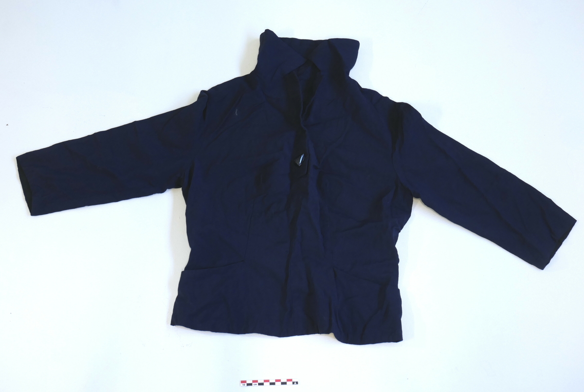 Kort, marineblå bluse/skjorte med 3/4 ermer, krage og ein stor, svart knapp i halsen