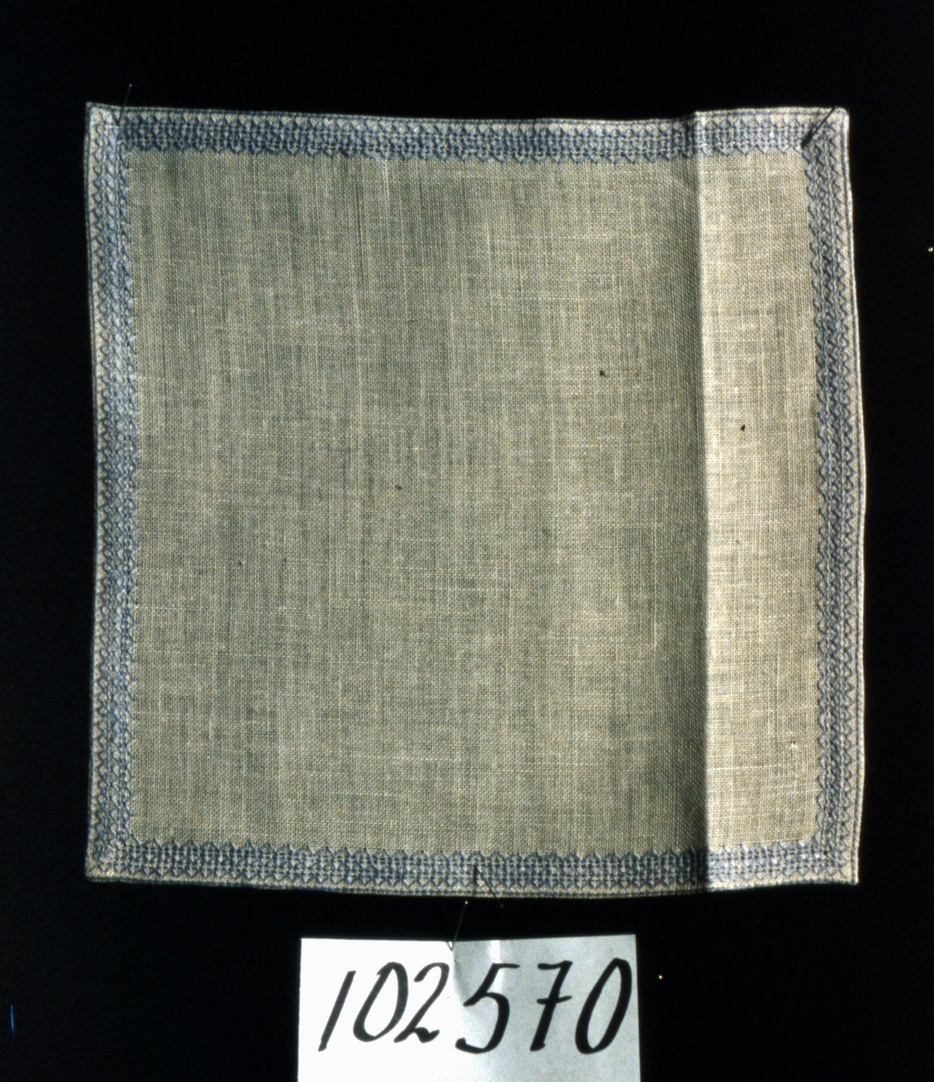 Duk, av blekt linne, kvadratisk form, broderad i kanten med svagt blårött lingarn, handfållad.