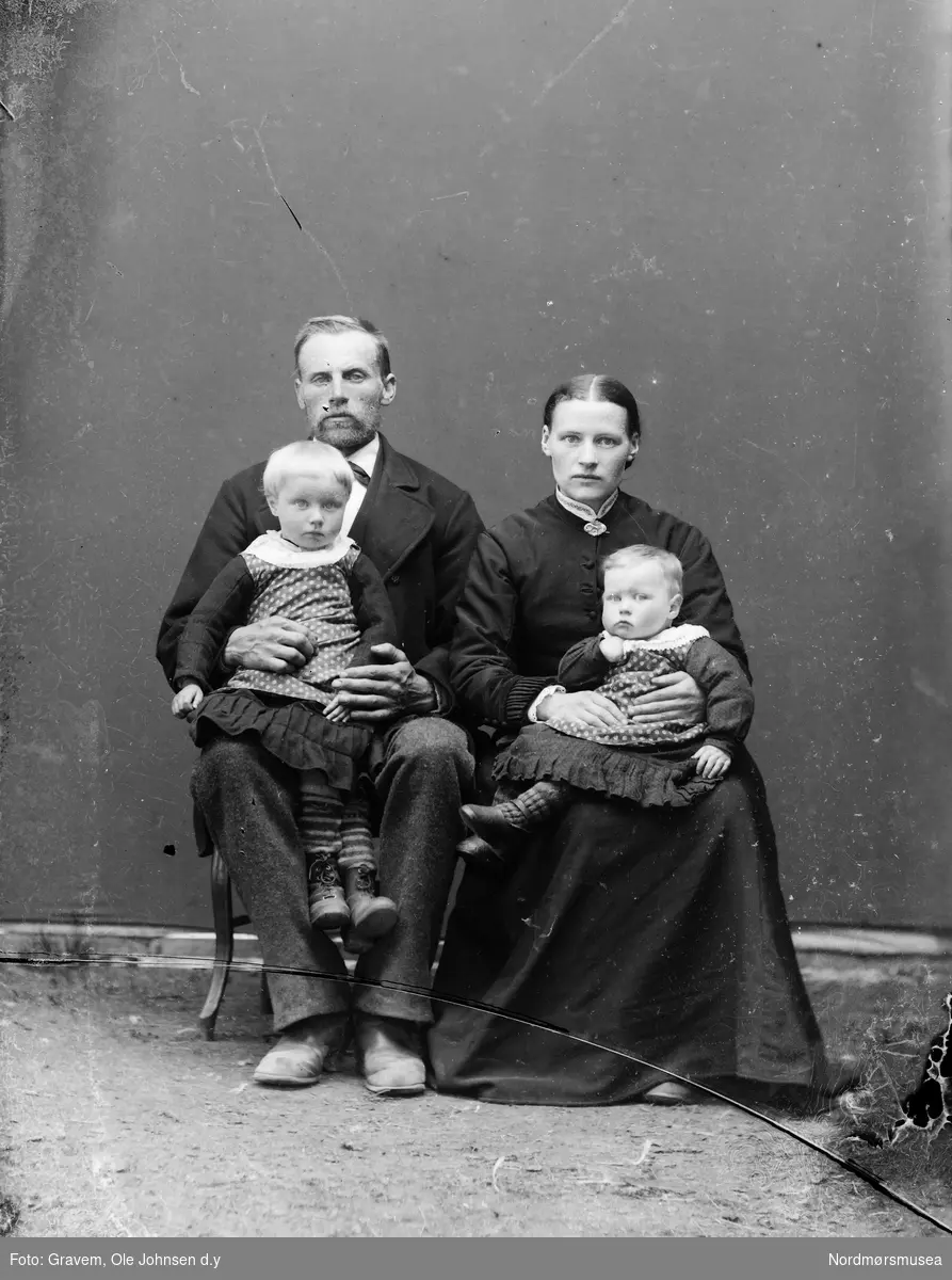 Familieportrett av kone og mann med to barn. 