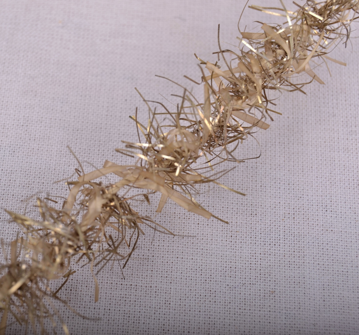 Lange lenker av tvunnet bomullshyssing med glittertråder stukket inn i hyssingen på tvers.