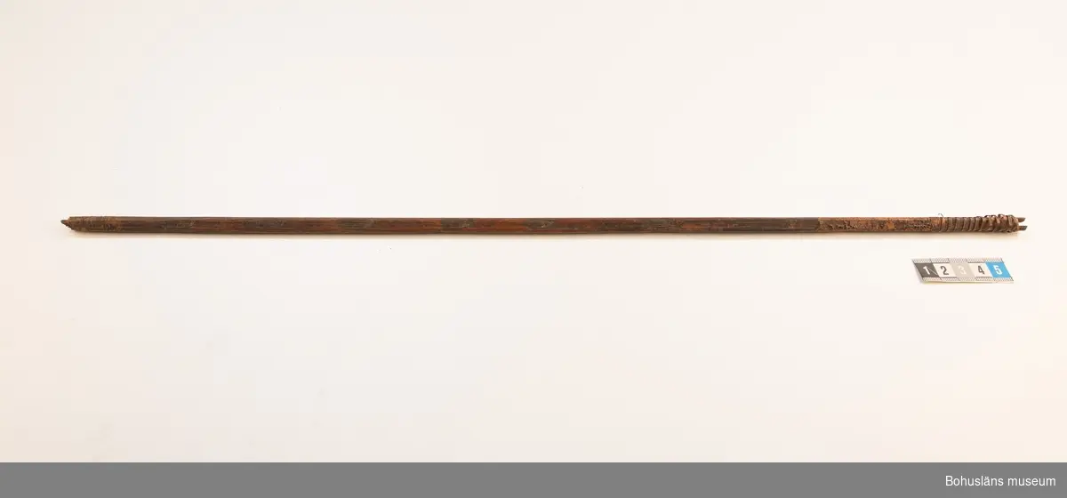 Ur handskrivna katalogen 1957-1958:
Båge m. 17 pilar, Afrika
Bågen a) L.103 cm; m. sträng av en vidja; i bågens ändar runda träkulor. Hel.
b-l, 3- kantiga m. smal svart fastsurrad träspets m. hullingar.
b-c, L. 72 och 71,2 cm; har blad infällda i ändan som styrfjädrar.
d-k, L. 75,5; 72; 71,8; 71,8; 71,6; 71,5; 76,6; 66 cm; lika b och c men saknar styrfjädrar;
k upptrasad i ändan.
L trasig i skaftet.
l, L. 55,5; av ngt annan typ än föreg, har haft spets och styrfjädrar, vila saknas. Trasig i främre änden.
m-r, runda skaft, styrfjädrar, spetsen av järn m. hullingar (ej 791 m) och holk f. fastsättn.
L. 69; 68,1; 76,4; 65; 64,7; 61,3 cm;
("r" saknar spets; n och q saknar en hulling. "o" saknar 2 styrfjädrar; "p" saknar ena delen i "klykan" f. strängen)

Ur Knut Adrian Anderssons Katalog II 1916:
No 22, nr 7, 8 ,9 på etiketten i Elmer Göranssons samling. Båge av trä m. sena till sträng jämte 17 förgiftade pilar av två typer med hullingar. Från Mogala i Belgiska Congo.

Artikel i Bohusläningen måndagen den 1 november 1937, "Vittberesta bohusläningar berätta. Upplevelser under 30-årig vistelse i Belgiska Kongo. Kapen Elmer Göransson. Folk och sedvänjor under ekvatorns glödande sol."

UMFA54467:0588 visar porträtt på sjökapten Elmer Göransson i uniform med ett antal ordnar och utmärkelser. Fotograf Thure Nihlén, Uddevalla.