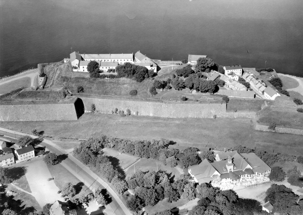 Flygbild över Varbergs slott och fästning. Översiktsbild av hela fästningen med vallarna med havet i bakgrunden Socitetsrestaurangen i Societetsparken i  förgrunden. Vallgraven var då torrlagd.
