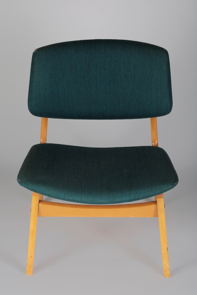 Stol i laminert tre med polstret sete og ryggbrett, trukket i grønt stoff. Sprossen foran og bak er buet i overkant. Sidesprossene utgjør delvis stolens sarg.