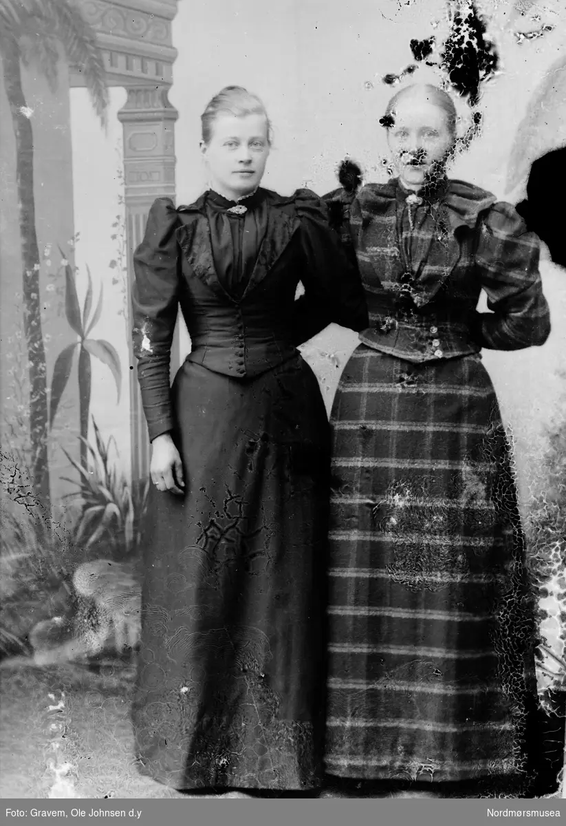 Portrett i helfigur av to kvinner i kjole. 