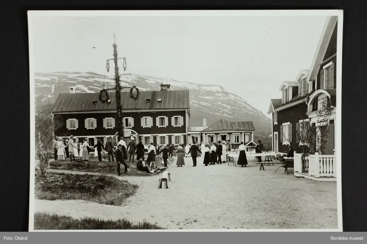 Dans runt majstången vid Abisko turiststation. "1907 fullbordades den s k paviljongen vid Abisko turiststation. I stora drag såg anläggningen ut likadant ända till 1949, då hela stationen brann upp. Den byggdes upp igen - i tegel!"
