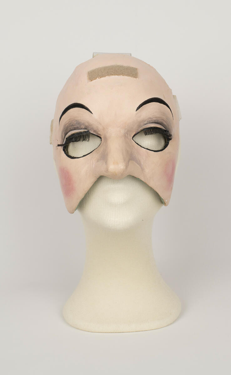 Dubbelmask använd för rollen "Baronen" i uppsättningen ”Pierrot i parken”.
Masken består av en halvmask som bärs över ansiktet och en ansiktsmask som bärs över bakhuvudet.