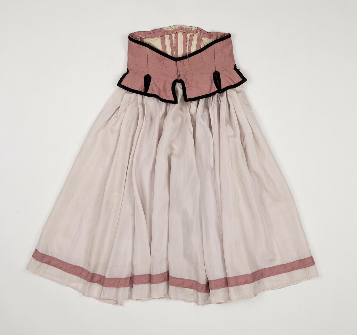 Kjol använd för rollen "Värdshusflicka" (en av flera)  i uppsättningen ”Pierrot i parken”.
Kjolen är tvådelad, dvs. kjolen består av ett korsettliv och en kjol som sytts ihop.