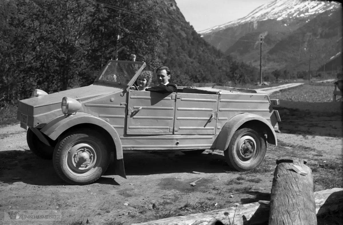 "Fra Eikesdalen, pinsen 1954".Frå Høvelreitan, Setra, gnr. 80..I bakgrunnen Finnsetlia med Brønnhøa over..Bilen tilhørte Marit M. Finset, Finnset turiststajson, og han gjekk som drosje i bygda.