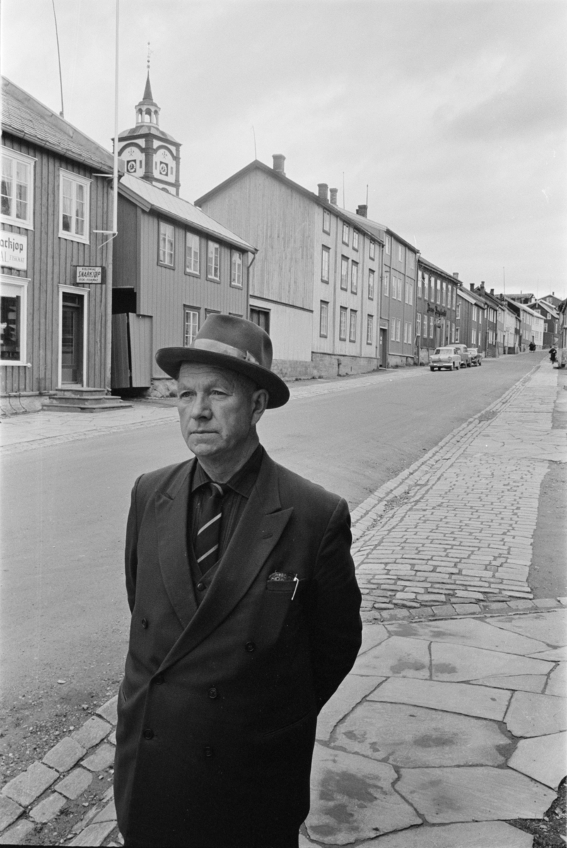 Portrett av en mann med hatt i en gate på Røros.