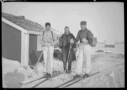 Tre menn foran ei hytte ved Joatka fjellstue. To menn har på