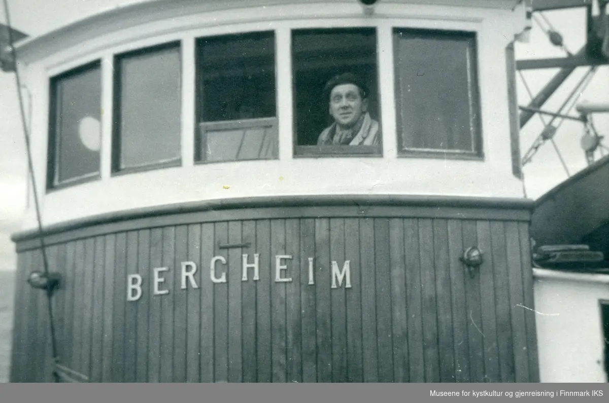 Asbjørn Berg ser ut av styrhuset på båten Mk "Bergheim".