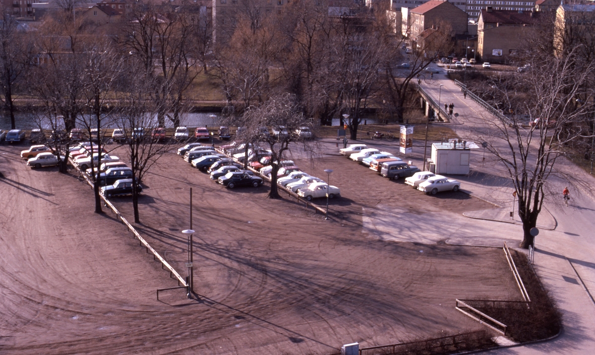 Parkeringsplats på Gamla Tanneforsvägen, Linköping år 1975. 
På parkeringsplatsen byggdes så småningom en brandstation. Den revs efter ett antal år och år 2017 började bostadshus byggas på platsen.
