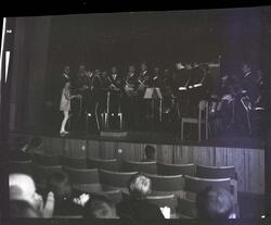 Fotografi av et orkester med mange menn som spiller på tromp