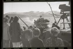 Fotografi av mange barn som står på en liten krigsbåt med en