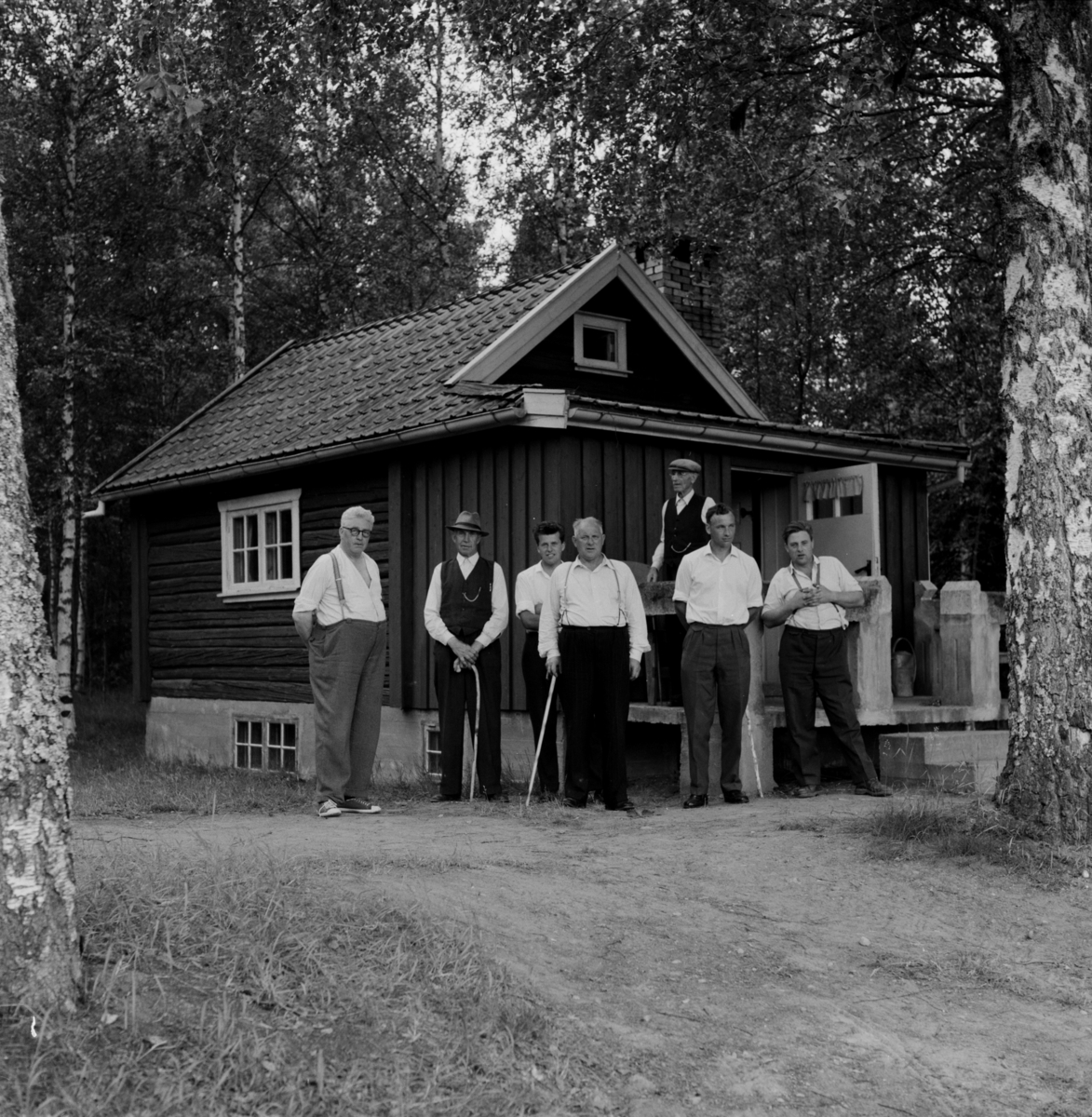 Gruppe menn ved hytte, antagelig i Gjerdrum