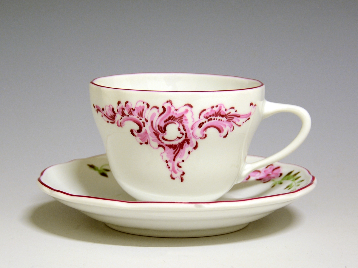 Kaffekopp av porselen. Håndmalte blomsterdekor, rosa blomster og grønne blader, gullstrek langs toppranden.
Modell: 1800, Victoria
Håndmalt dekor av Knut Andersen