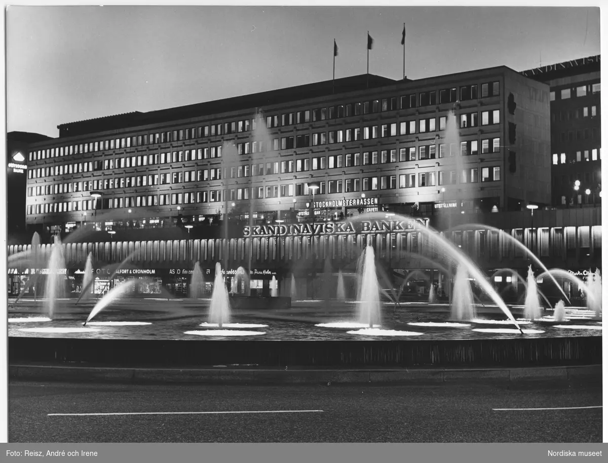 Stockholm. Kvällsbild. Skandinaviska Bankens byggnad, uppförd 1963-1966 efter ritningar av Kjell Ödeen, på Sveavägen, i förgrunden Sergels torgs fontän färdigställd 1968.