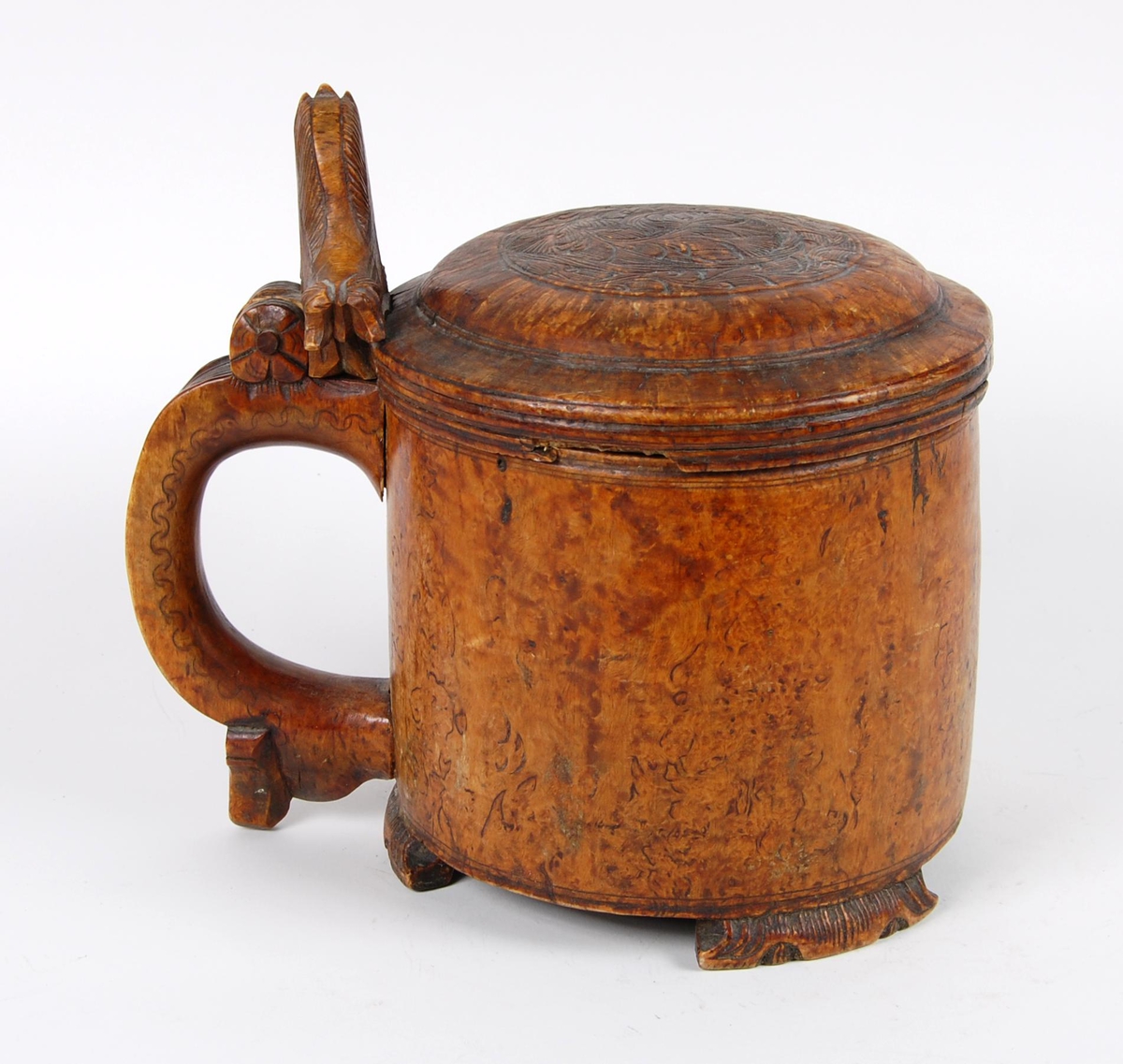 Kanne av dreid valbjørk. Lokk med akantusskurd. Løveformet lokkåpner. Hank med bladranke. Tre løveføtter.